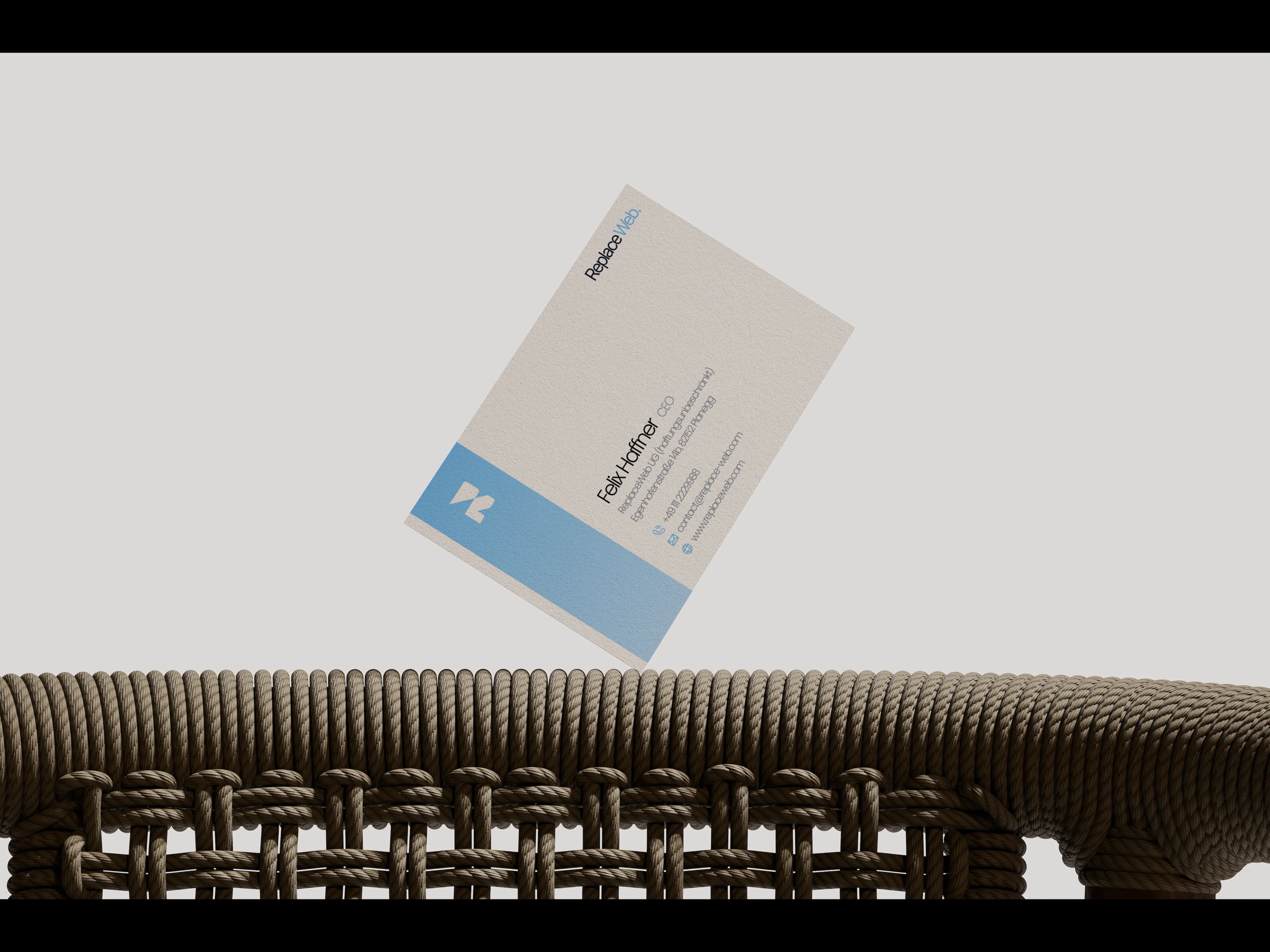 ReplaceWEB. business card against a woven chair back